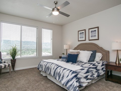 A bedroom with a large bed and a ceiling fan.