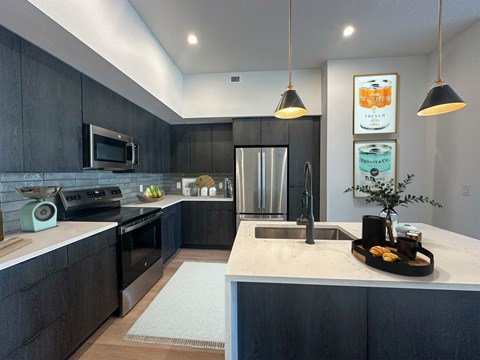 A modern kitchen with dark wood cabinets and a white countertop.