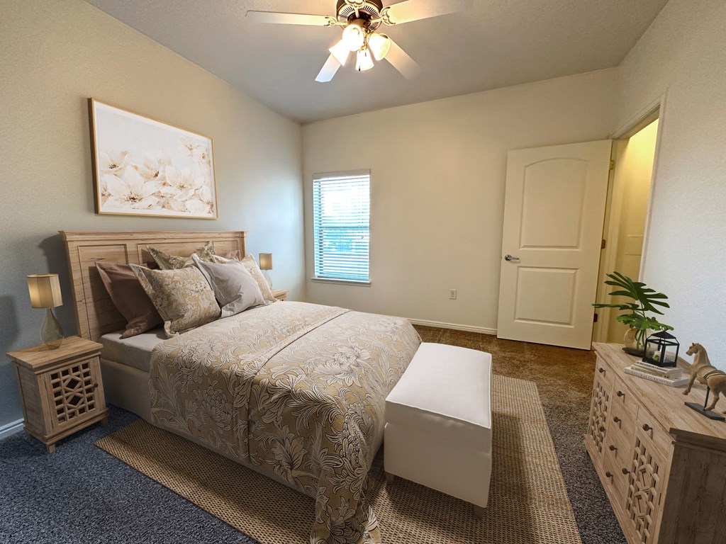 Liberty Landing Apartments in West Jordan Utah bedroom with a full-sized bed and ceiling fan.