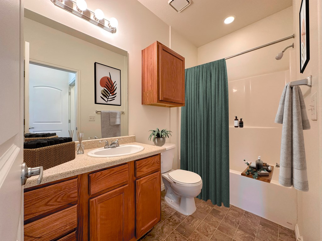 Liberty Commons Apartments, West Valley City, Utah, a bathroom with a sink, toilet, bathtub and shower and a green curtain