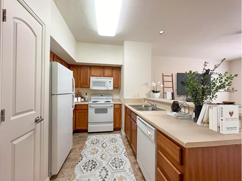 a kitchen with white appliances and wooden cabinets