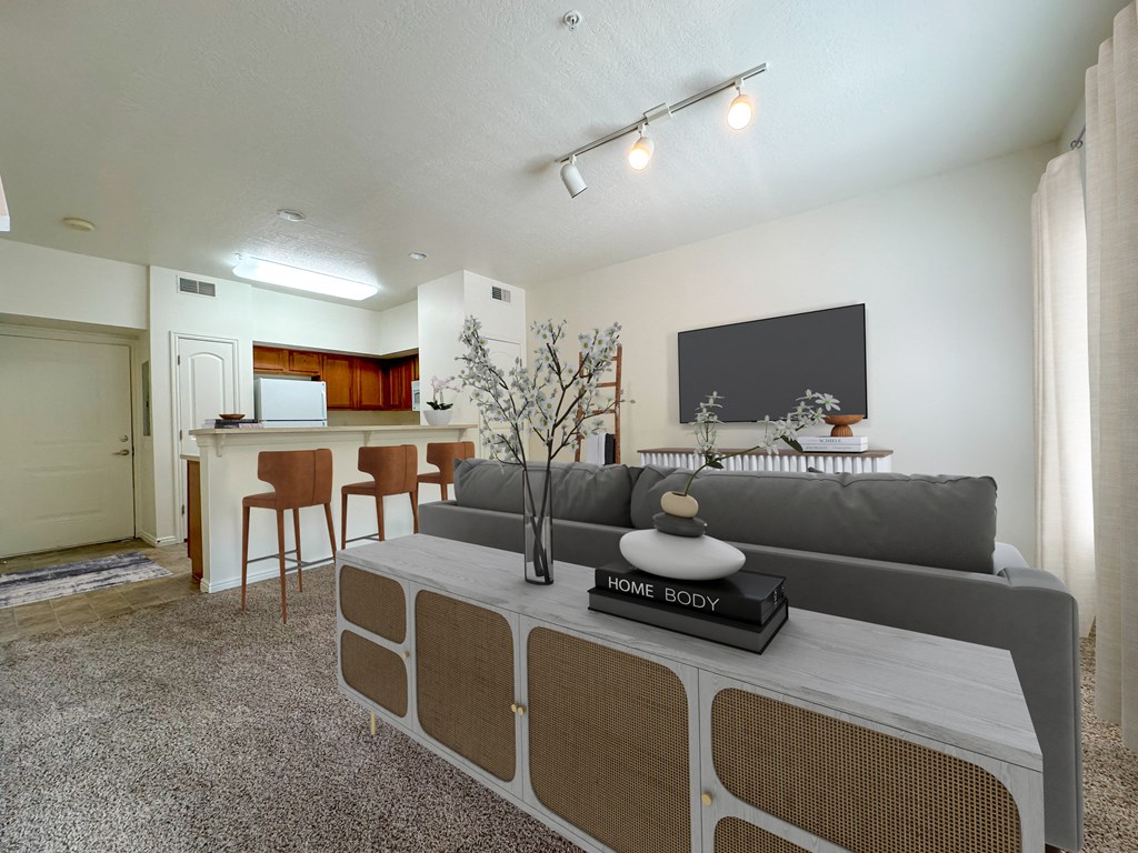 Liberty Commons Apartments, West Valley City, Utah, a living room with a couch, entryway storage, television, barstools and kitchen in the background.