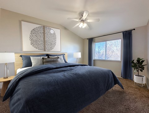 A bedroom with a large bed and a ceiling fan.
