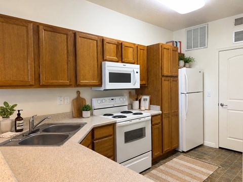 A kitchen with wooden cabinets and white appliances.