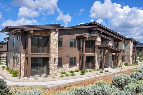 A modern house with a brown exterior and stone pillars.