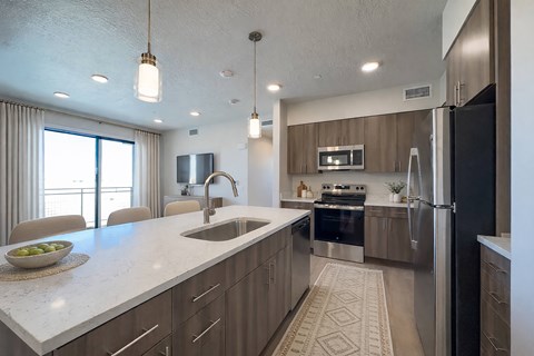 A modern kitchen with a large island and stainless steel appliances.