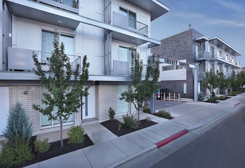Liberty Square Apartments Townhomes Salt Lake City Utah with a sidewalk and trees in front of it