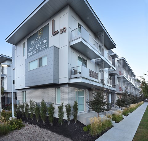 the exterior of Liberty Square Apartments Townhomes Salt Lake City Utah with a sidewalk in front of it