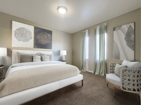 A bedroom with a large bed and a chair.