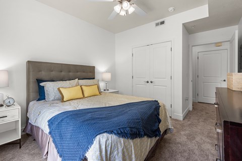 A bedroom with a bed covered in a blue blanket.