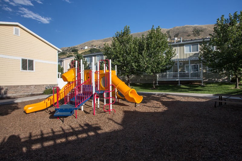 Liberty Hill Apartments, Draper, Utah, playground with a yellow slide and red and blue play equipment.