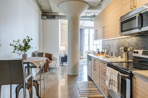 gorgeous modern kitchen in Maxfield loft with light wood cabinets, modern fixtures, updated appliances, and beautiful blue tile backsplash