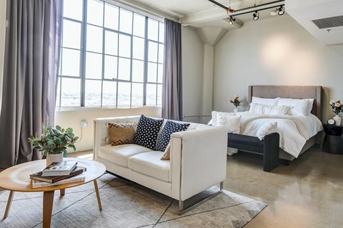 Spacious open concept loft at Maxfield with high wall-to-wall windows, cozy bedroom space, and room for a living area