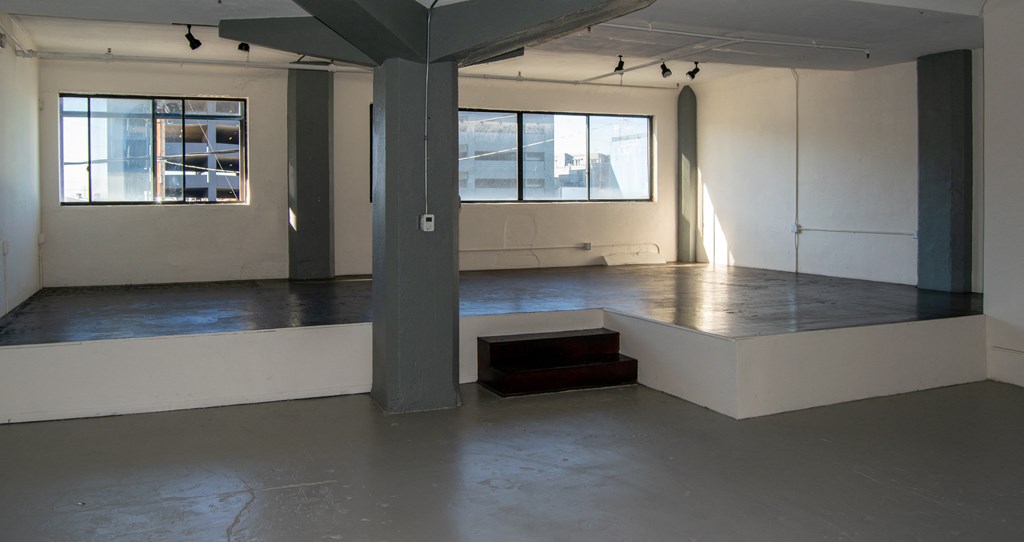 a large empty room with a stage in the middle at Binford Lofts Apartments, Los Angeles , 90013