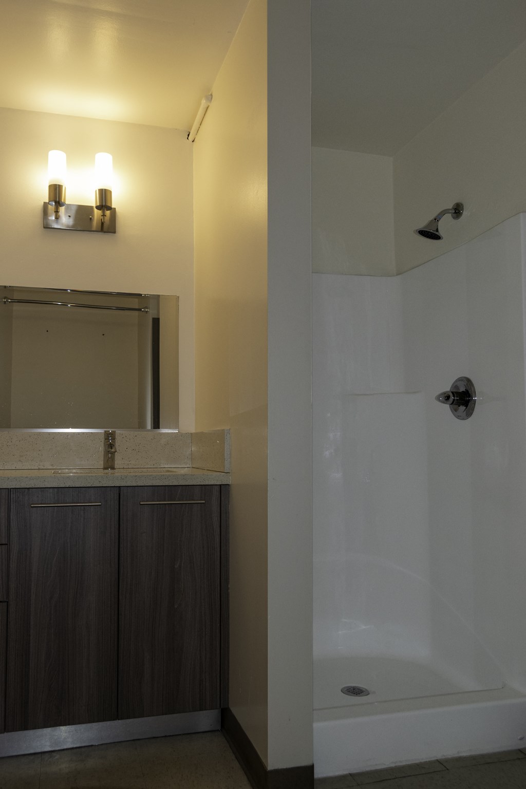 a bathroom with a shower and a sink and a mirror at Binford Lofts Apartments, California
