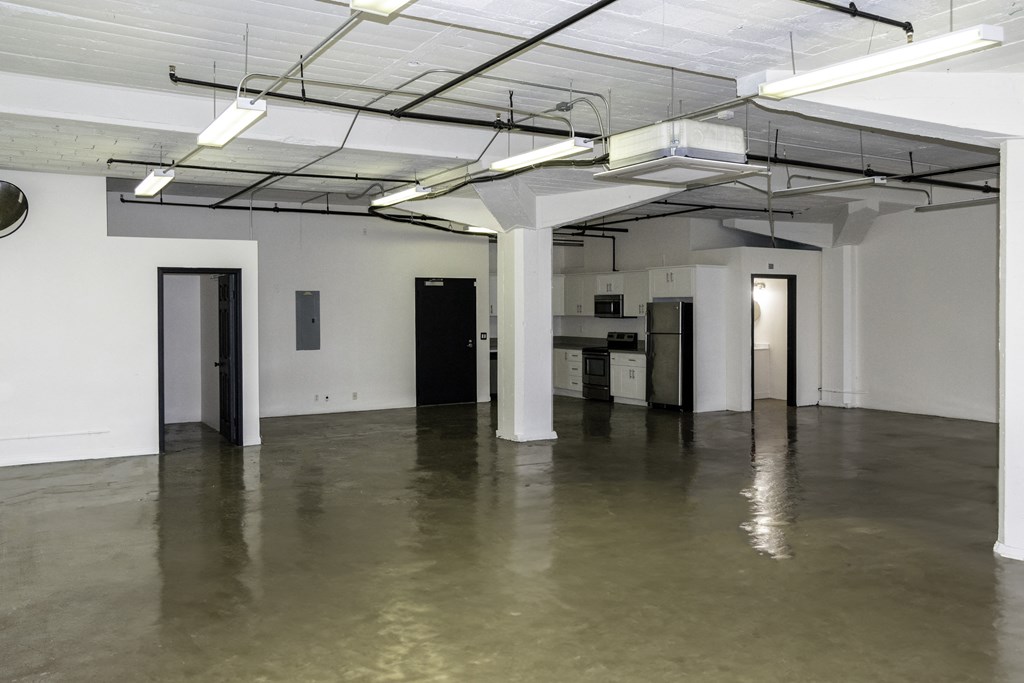 a large empty room with white walls and a cement floor at Binford Lofts Apartments, Los Angeles , CA