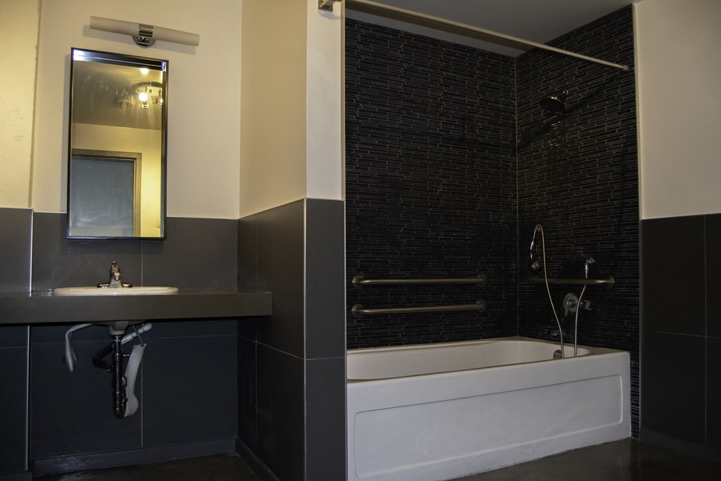 a black and white bathroom with a tub and a sink at Binford Lofts Apartments, California, 90013