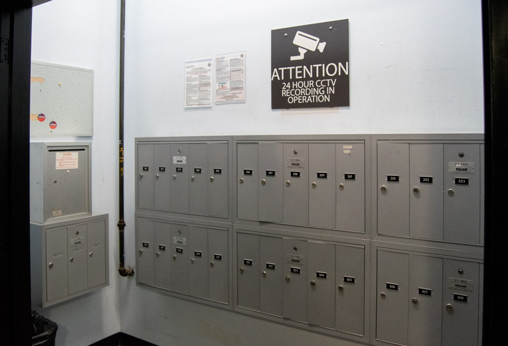 a row of lockers in a room with a sign on the wall at Binford Lofts Apartments, Los Angeles , CA