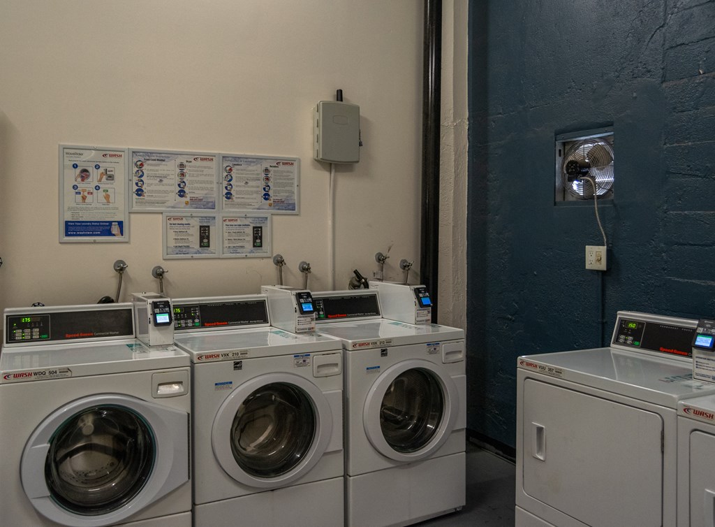 a laundry room with four washers and four washing machines at Binford Lofts Apartments, Los Angeles , California