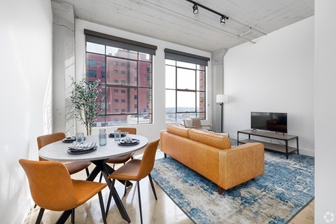 A living room with a white table and orange chairs.