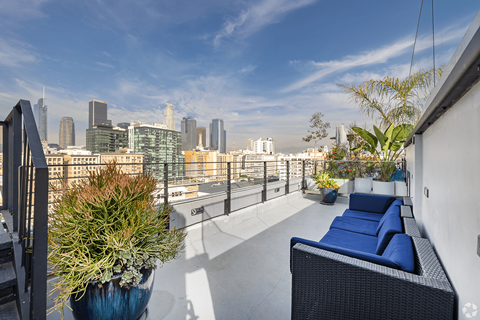 A balcony with a blue couch and a view of the city.