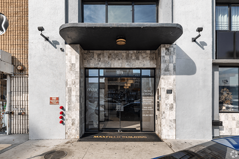 The image shows the front of a building with a large glass door entrance.