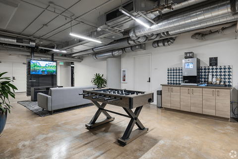 A room with a pool table and a TV mounted on the wall.