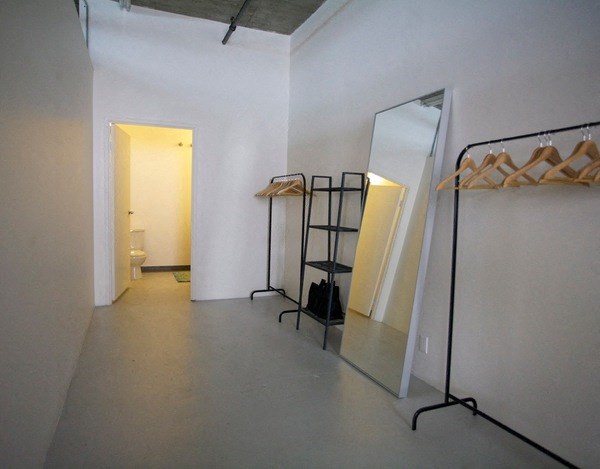 a room with mirrors and a hallway with a bathroom in the background at Binford Lofts Apartments, Los Angeles , CA