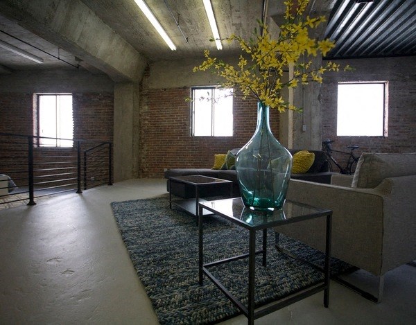 a living room with a glass vase with flowers on a table at Binford Lofts Apartments, Los Angeles , 90013