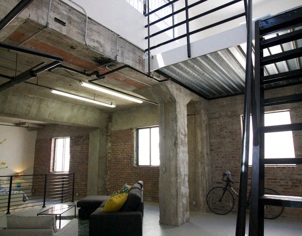 a loft with a staircase and a couch and a bike in it at Binford Lofts Apartments, Los Angeles , CA