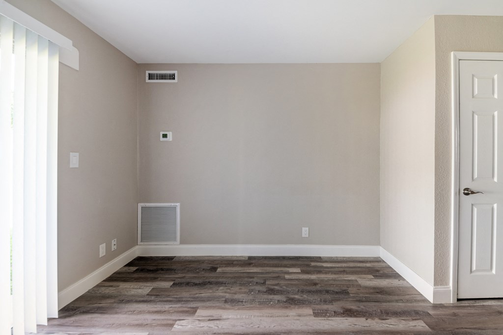 an empty room with wooden floors and a white door at Palm Cove Apartments, Florida