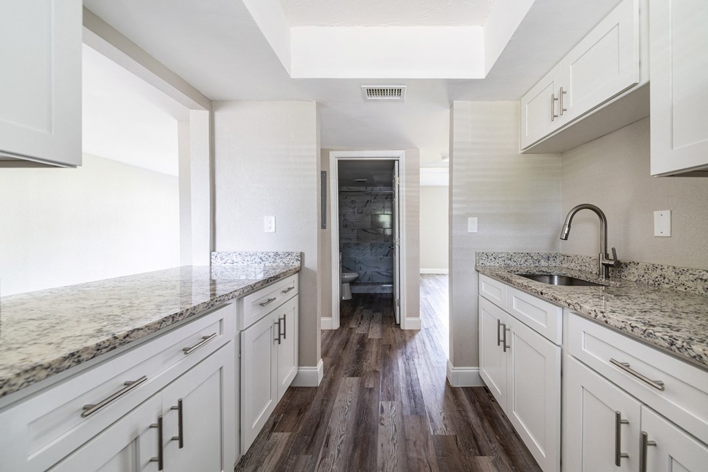 a kitchen with white cabinets and marble counter tops a kitchen with white cabinets and marble counter tops at Palm Cove Apartments, Daytona Beach, FL