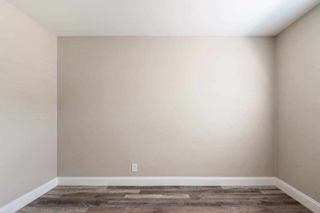 an empty room with white walls and a wooden floor at Palm Cove Apartments, Florida