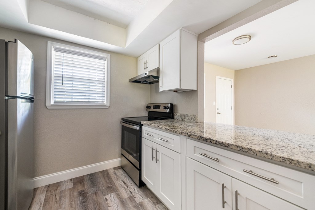 a kitchen with white cabinets and a granite counter top at Palm Cove Apartments, Daytona Beach Florida