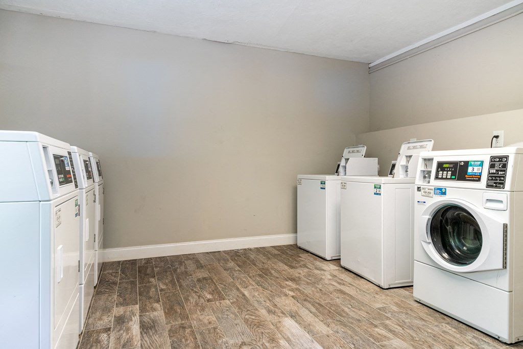 a laundry room with washes and dryers and a combination of washing machines at Palm Cove Apartments, Daytona Beach, FL 32114