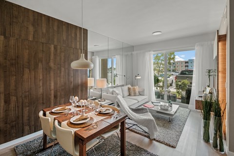 A modern dining room with a wooden table and chairs.