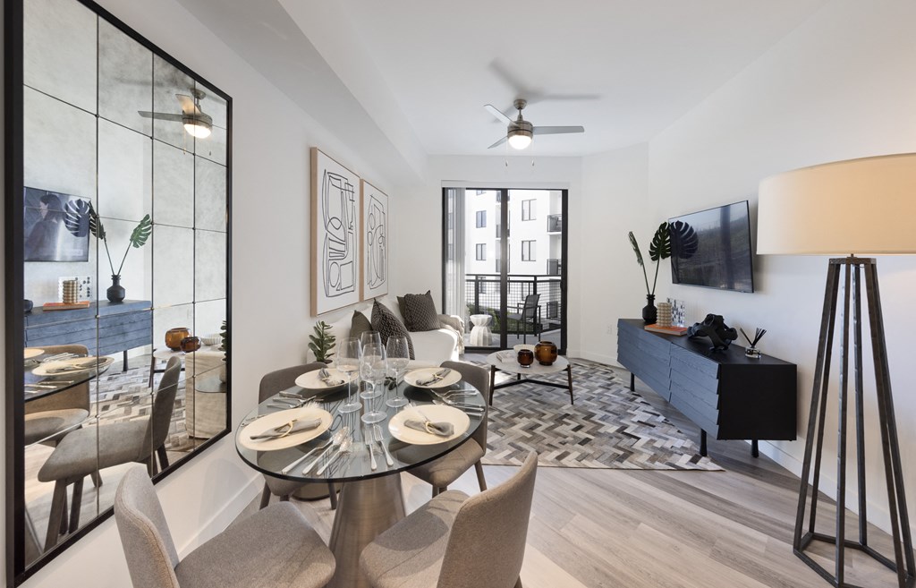 A modern dining room with a glass table and chairs.
