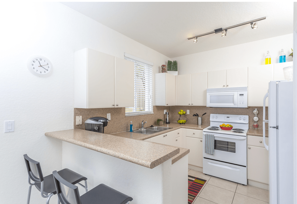 a kitchen with white cabinets and a granite counter top