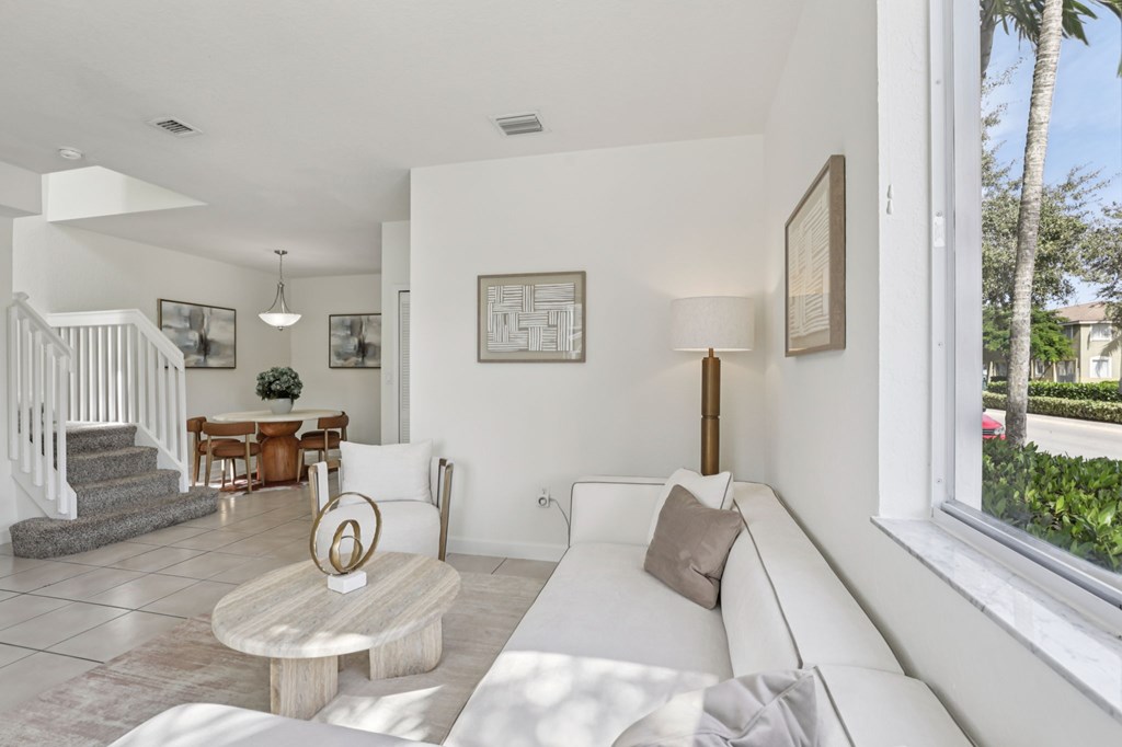 A white living room with a couch, coffee table, and pictures on the wall.
