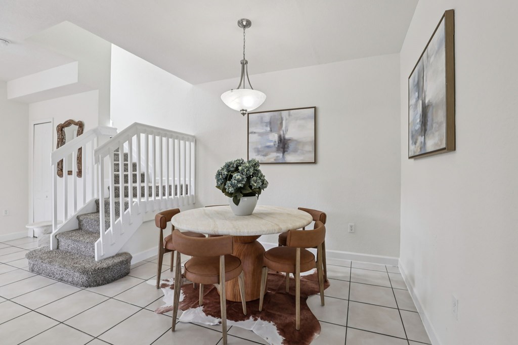 A dining room with a table and chairs.