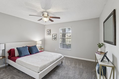 A bedroom with a large bed and a ceiling fan.