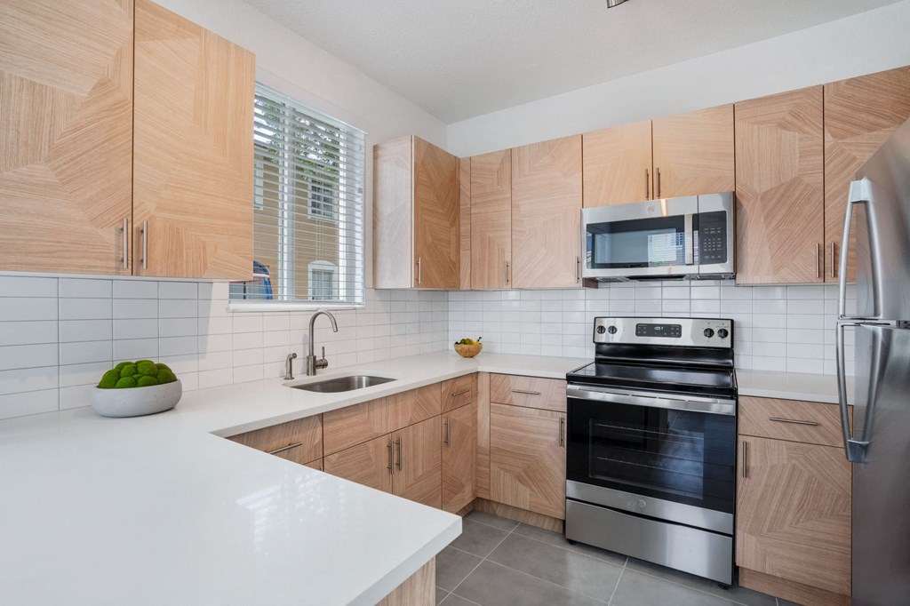 a modern kitchen with wooden cabinets and stainless steel appliances