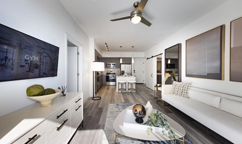 A modern living room with a white couch and a ceiling fan.