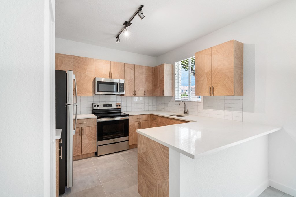 a kitchen with white countertops and wooden cabinets