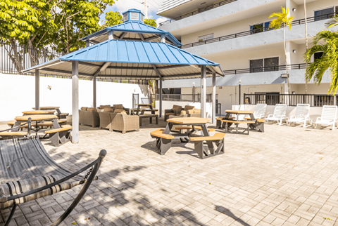 a large patio with picnic tables and chairs and a gazebo at Lakeside @ Biscayne Gardens,North Miami, FL,33181