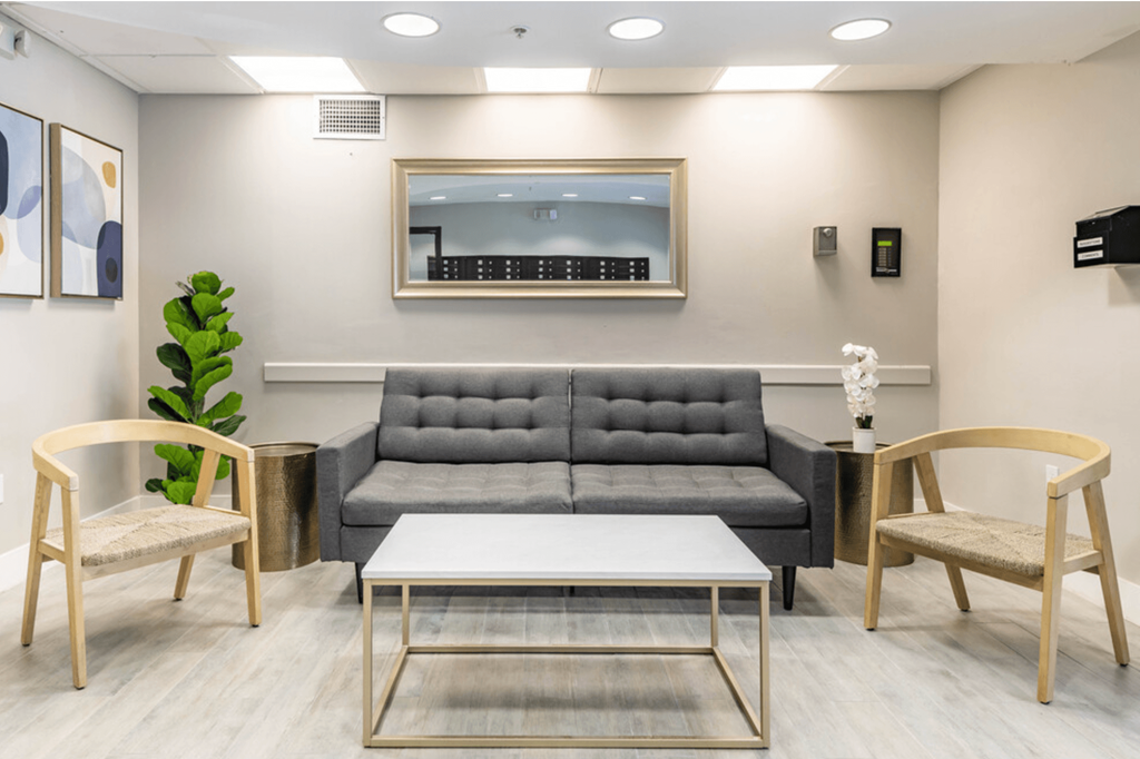 a living room with a gray couch and two chairs at Lakeside @ Biscayne Gardens,North Miami, Florida