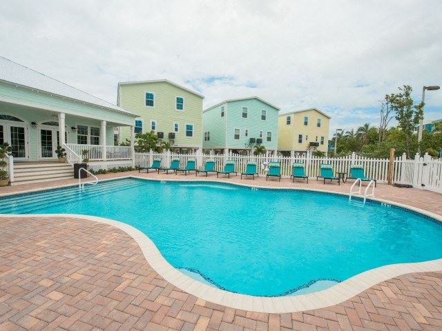a large blue swimming pool with chairs around it
