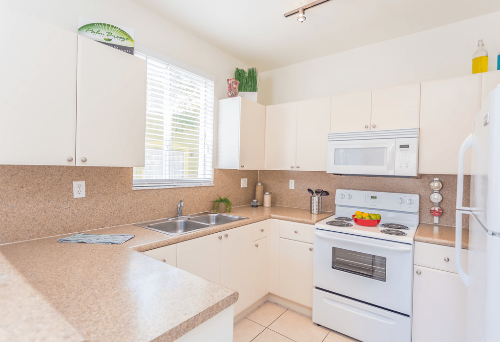 a kitchen with white cabinets and a white stove top oven