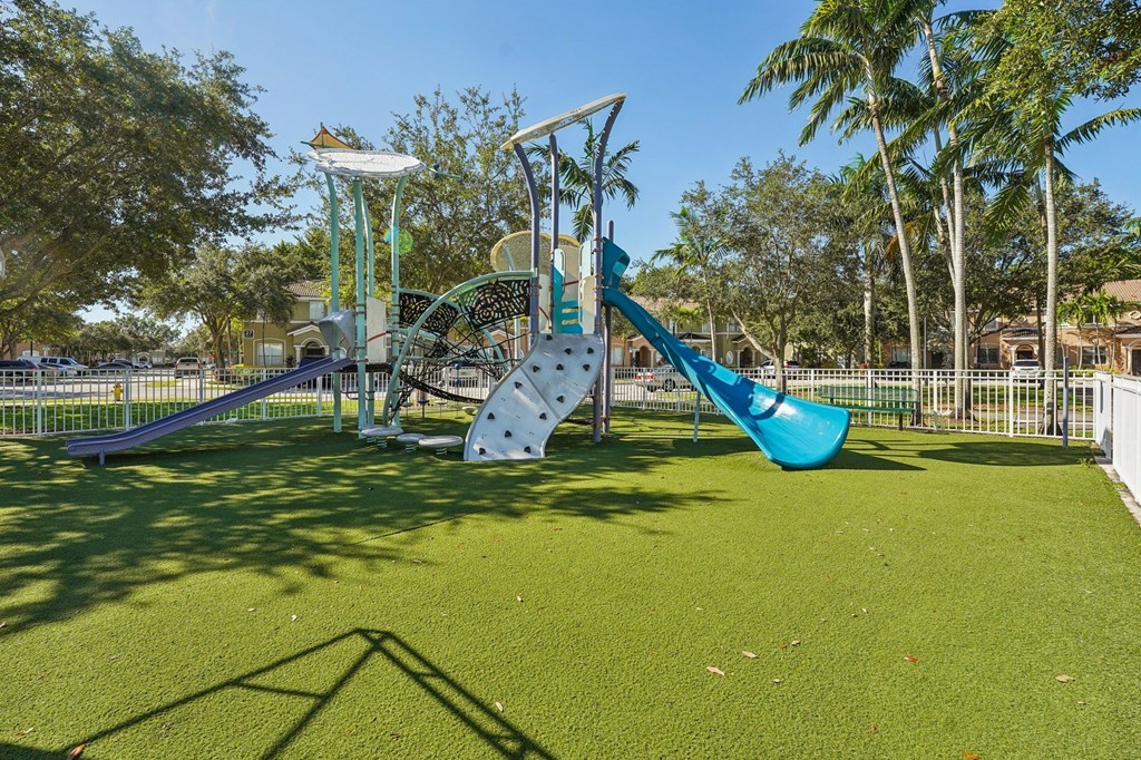 A playground with a blue slide and a white structure.