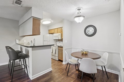 A kitchen with a table and chairs.